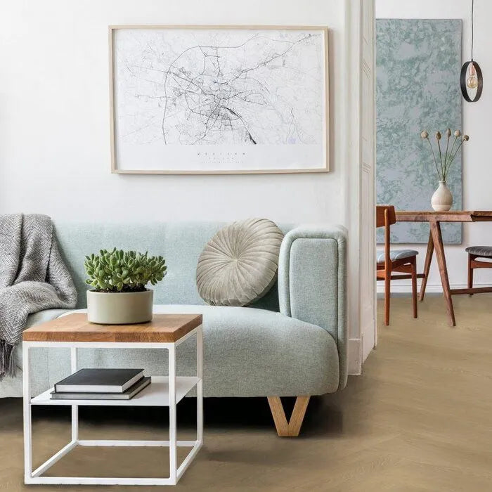 licht eiken vloer met brede planken in visgraatpatroon gecombineerd met modern interieur met zacht blauwgrijze bank en houten bijzettafel met wit metalen frame