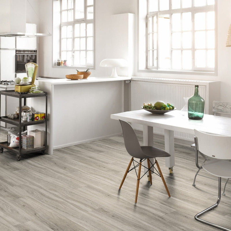 lichte grijsbruine vloer met houtstructuur en subtiele nerven, brede planken in moderne keuken met wit meubilair en grote ramen