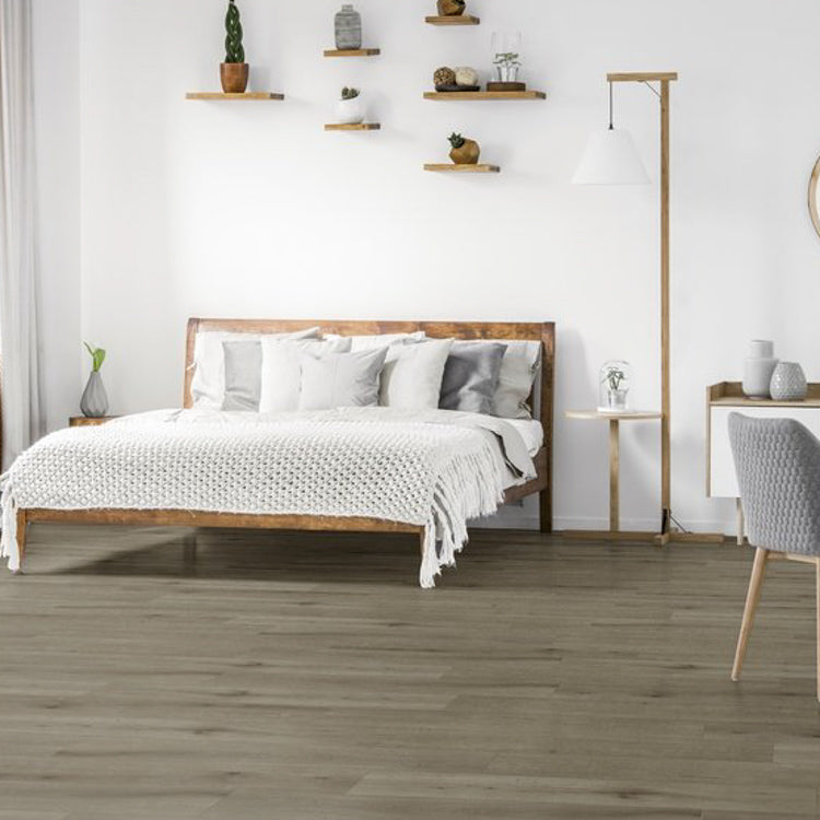 lichtgrijs eiken vloer met brede planken in een slaapkamer met een houten bed en witte gebreide deken