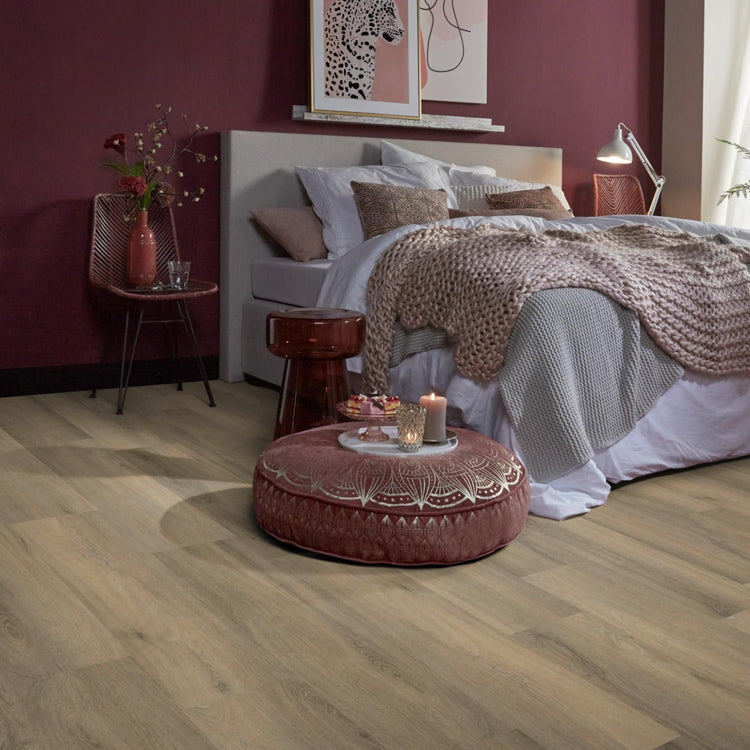 lichte beige eiken vloer met brede planken en subtiele houtnerfstructuur in een slaapkamer met een zachtroze wand, wit beddengoed en een gebreid plaid