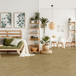 lichte beige vloer met visgraat patroon en brede planken, gecombineerd met een lichte houten bank met groene en witte kussens en natuurlijke decoratie in een lichte, open woonkamer en eetgedeelte