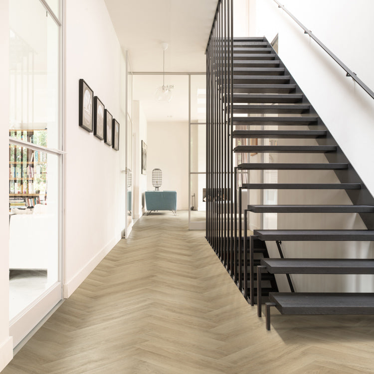 licht beige visgraatvloer met smalle planken in een modern interieur met zwarte open trap en witte wanden
