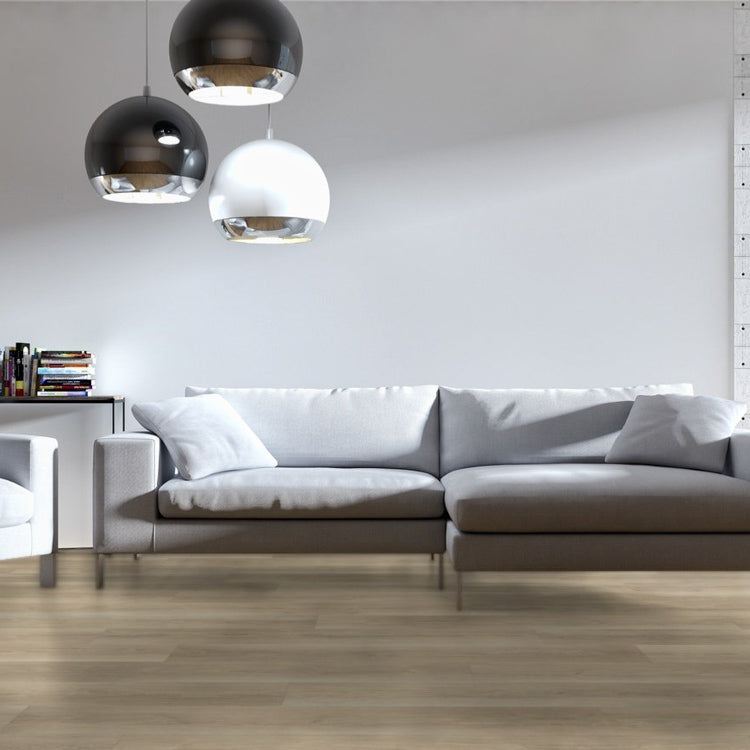 lichte beige eiken vloer met brede planken en subtiele houtnerfstructuur in moderne woonkamer met grijs stoffen hoekbank en drie hanglampen in zwart en wit