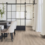 licht eiken vloer met brede planken en een subtiele houtstructuur in een lichte, natuurlijke tint onder een moderne eethoek met velvet beige stoelen en een industriële zwarte schuifdeur van glas en staal