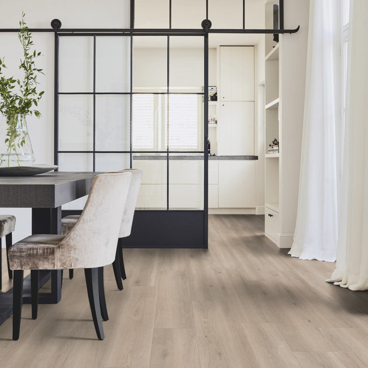 licht eiken vloer met brede planken en een subtiele houtstructuur in een lichte, natuurlijke tint onder een moderne eethoek met velvet beige stoelen en een industriële zwarte schuifdeur van glas en staal