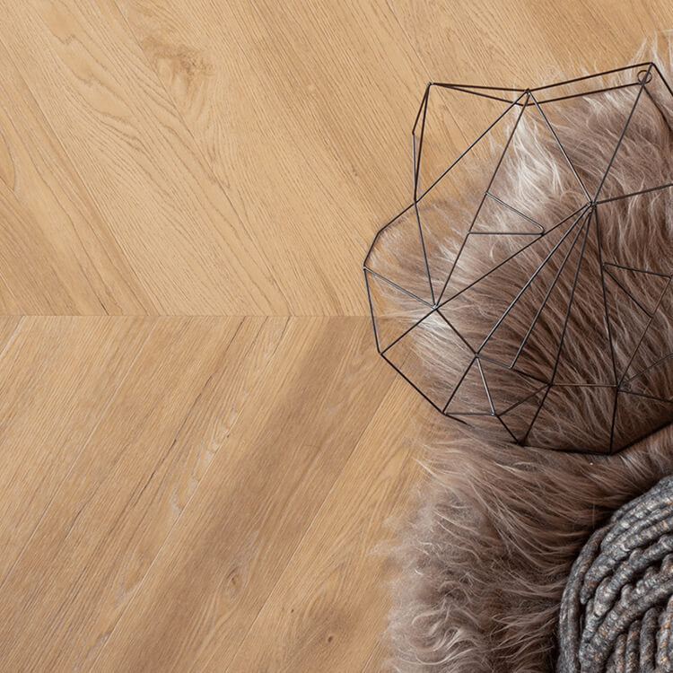 licht eiken vloer met visgraatpatroon en fijne houtstructuur, afgebeeld met een zacht bruin grijs tapijt en een zwart metalen geometrisch mandje erop