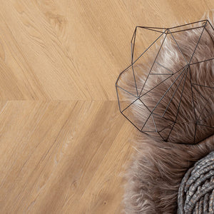 lichte beige eiken visgraatvloer met subtiele houtnerfstructuur en brede planken