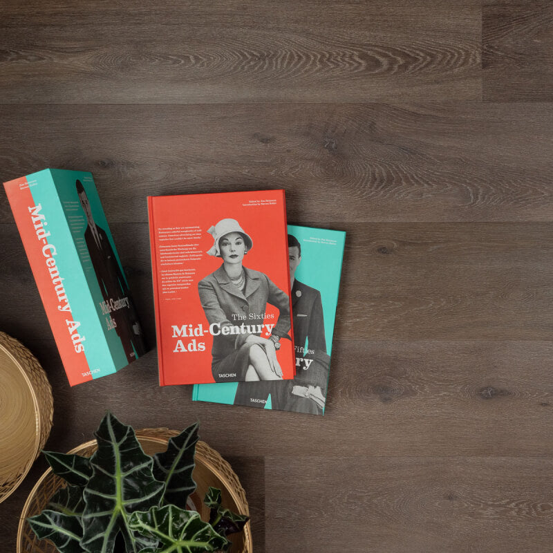 donkerbruin eiken vloer met lichte houtnerven en subtiele structuur, brede planken, met drie boeken en een groene plant op de vloer