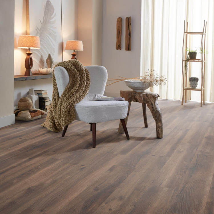 donker grijs bruin vloer met brede planken en subtiele houtnerfstructuur in moderne sfeervolle woonkamer met lichtgrijze fauteuil en houten bijzettafel