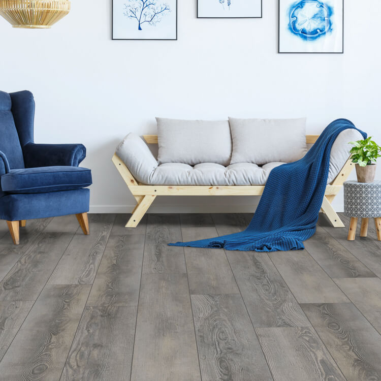 donkergrijs eiken vloer met brede planken en zichtbare houtstructuur in een moderne woonkamer met blauwe fauteuil, lichte houten bank en blauwe gebreide plaid