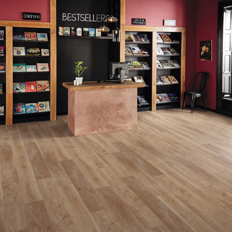 lichte vloer in licht beige eiken kleur met brede planken en een subtiele houtstructuur, gelegen in een boekenwinkel met houten toonbank en zwarte boekenrekken tegen een donkere wand met rode accenten