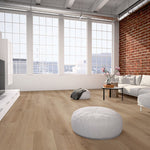 lichte beige eiken vloer met brede planken en subtiele houtstructuur in moderne woonkamer met grote raampartij en bakstenen muur