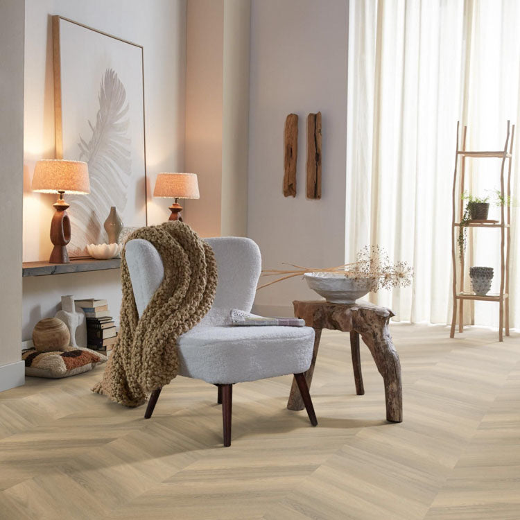 licht eiken visgraatvloer met fijne houtnerfstructuur in lichte beige tint, moderne woonkamersetting met witte fauteuil en naturel houten bijzettafel