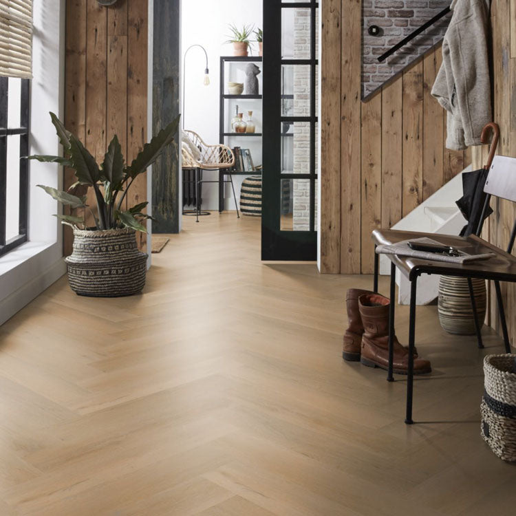 lichte vloer in visgraatpatroon met brede planken in licht beige eiken kleur, gecombineerd met houten wandbekleding en natuurlijke accessoires in halruimte met veel daglicht