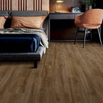 donkerbruin eiken vloer met brede planken en natuurlijke houtstructuur in slaapkamer met grijs gestoffeerd bed, bruin leren kussen en modern zwart bureau