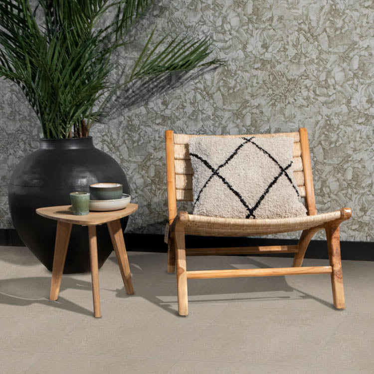licht beige tegelvloer met grote vierkante tegels en subtiel structuurpatroon, houten stoel met beige zitting en zwart-wit kussen, lichte houten bijzettafel met keramische kopjes, groene grote vaas met groene planten, bloemmotief behang in grijstinten