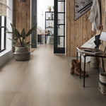 lichte beige eiken vloer met brede planken en een subtiele houtstructuur in een moderne hal met houten wandbekleding en zwart metalen deurkozijnen