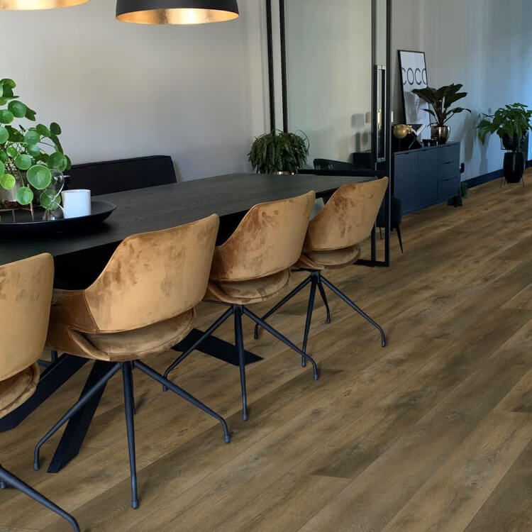 lichte bruin eiken vloer met brede planken en subtiele houtnerfstructuur in een moderne eetkamer met velvet beige stoelen en zwarte tafel