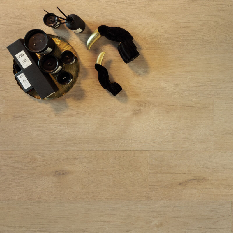 lichte beige eiken vloer met brede planken en subtiele houtstructuur, met zwarte en gouden decoratieve accessoires op de vloer geplaatst