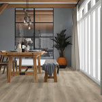 lichte eiken vloer met brede planken en subtiele houtnerfstructuur in een moderne eetkamer met robuuste houten tafel en banken, grote ramen en grijze muren