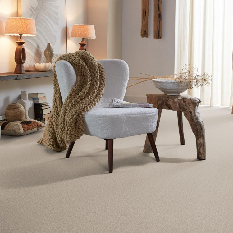 licht beige effen tapijt met zachte, fijne structuur in moderne woonkamer met witte fauteuil en rustiek houten bijzettafel