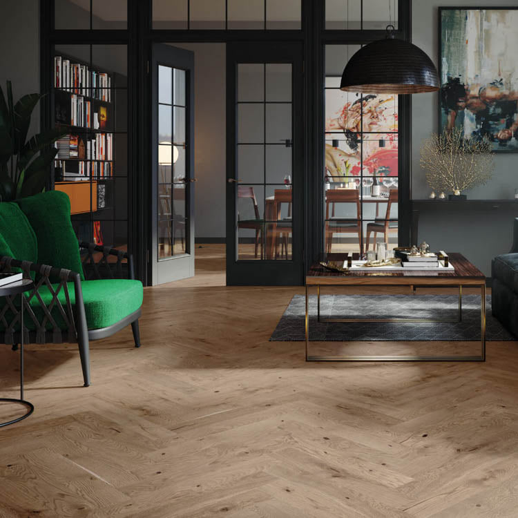 licht eiken visgraat vloer met fijne houtstructuur in een moderne woonkamer met groene fauteuil, donkere metalen en glazen taatsdeur, en donkergrijs vloerkleed onder een houten salontafel