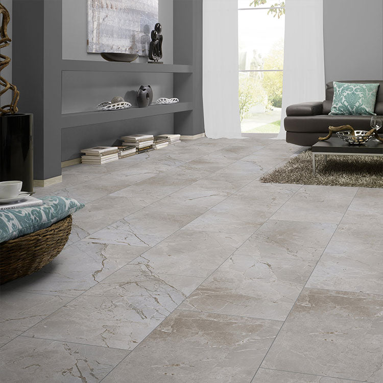 Tegelvloer met grote rechthoekige tegels in licht taupe en beige marmerstructuur met subtiele golvende aders in crème en grijs, in een moderne woonkamer met grijs geschilderde muren en gezellig interieur.