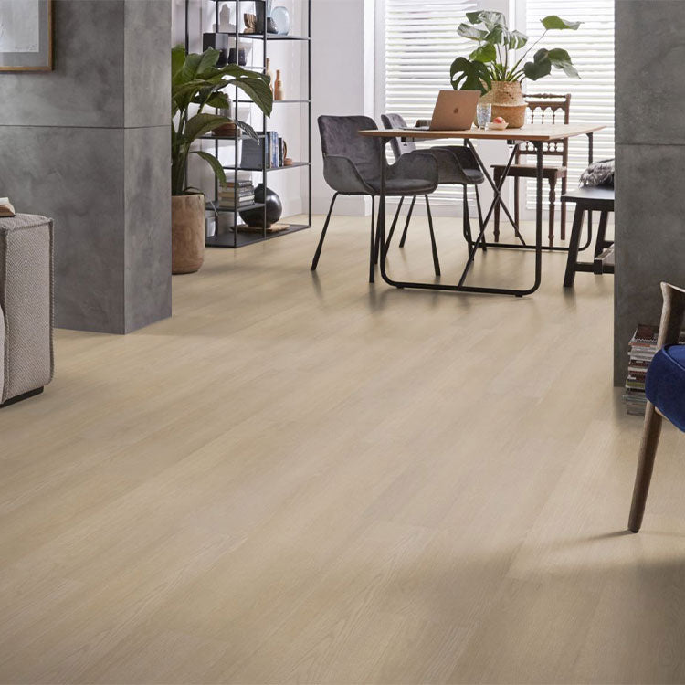 Licht eiken vloer met een subtiele houtnerfstructuur en brede planken in een natuurlijke, lichte beige tint, gecombineerd met modern interieur en zwart metalen stoelpoten.