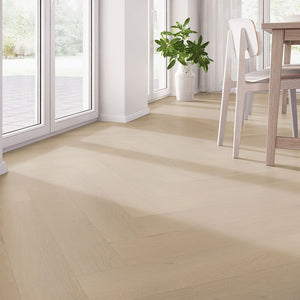 Licht beige eiken vloer in visgraatpatroon met subtiele houtstructuur en brede planken.