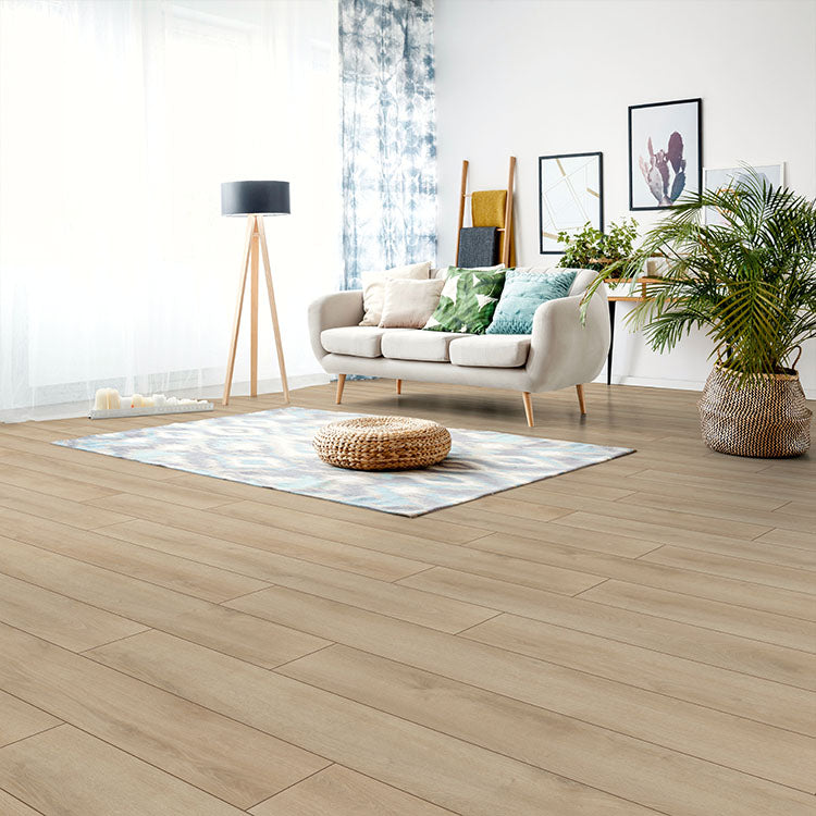 Lichte vloer in effen beige eiken kleur met brede planken in horizontaal gelegd patroon, gecombineerd met lichte neutrale woonkamerinrichting en accessoires.