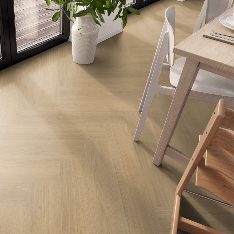 licht eiken vloer in visgraat patroon met een gladde structuur, brede planken, in een lichte woonkamer met houten tafel en witte stoelen