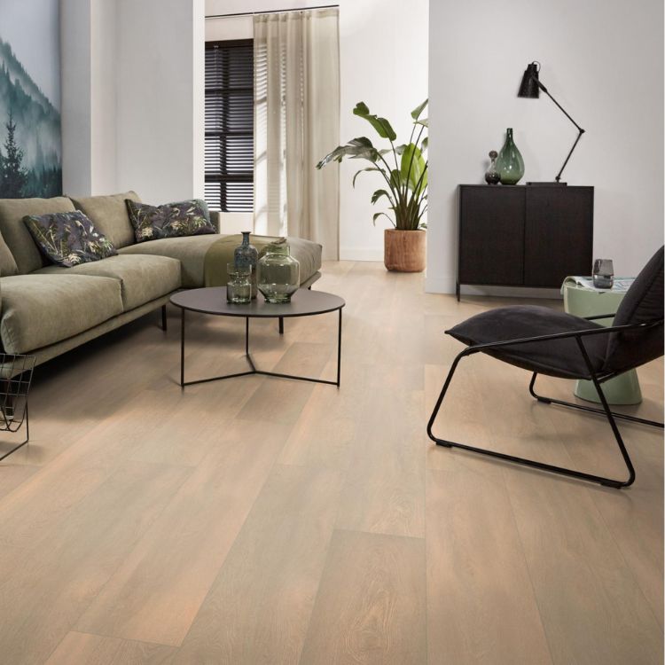 lichte beige eiken vloer met brede planken en subtiele houtstructuur in modern ingerichte woonkamer met groene bank en zwarte metalen bijzettafel