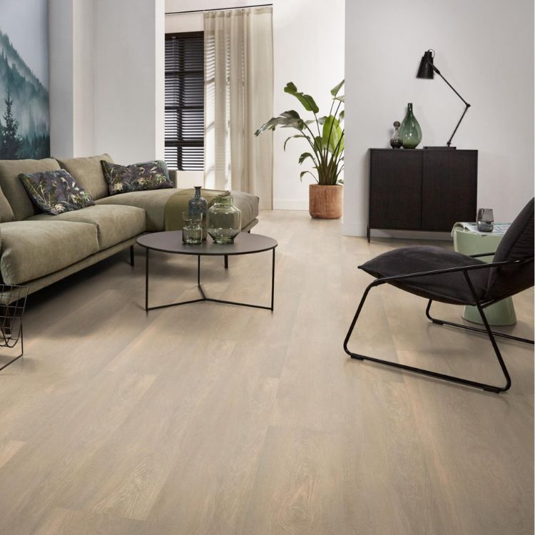 lichte vloer in brede planken met een zachte beige eiken houtstructuur in moderne woonkamer met groene bank en zwarte metalen bijzettafel