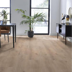 lichte beige eiken vloer met brede planken en subtiele houtnerfstructuur in moderne lichte woonkamer met zwarte meubelen en groene kamerplant naast grote ramen