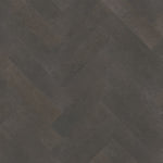 donkergrijze tegelvloer met subtiel golvend patroon en matte structuur in visgraatmotief