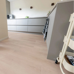 lichte beige eiken vloer met brede planken en subtiele houtstructuur in moderne keuken met grijze kasten en minimalistisch design
