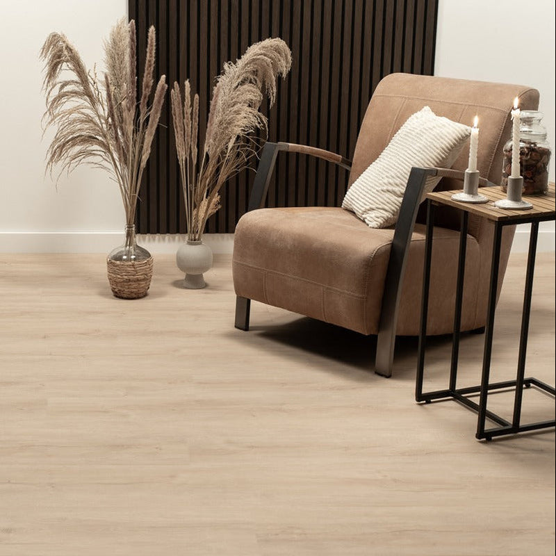 lichte beige eiken vloer met zachte houtstructuur, brede planken, in een moderne woonkamer met een bruine leren fauteuil en decoratieve pampasgras in vazen