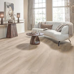 lichte beige eiken vloer met brede planken en subtiele houtnerfstructuur in moderne woonkamer met lichtgrijze bank en donkere houten meubelen