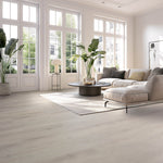 Lichte beige eiken vloer met brede planken en subtiele houtnerfstructuur in een moderne woonkamer met grote witte ramen.