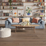 lichte grijs bruine vloer in brede planken met subtiele houtstructuur, moderne woonkamer met lichtblauwe bank en houten salontafel