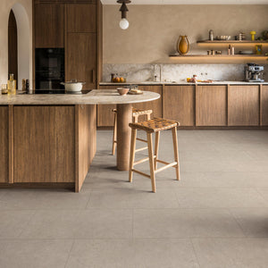 beige tegelvloer met grote tegels en een subtiel korrelig structuurpatroon in lichte zandkleur met kleine spikkels