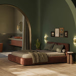 lichte beige eiken vloer met brede planken in rechte gelegd patroon in moderne slaapkamer met donkergroen geschilderde muren en rustbruin leren laag bed met gestreepte kussens