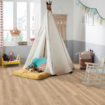 lichte beige eiken vloer met een fijne houtnerfstructuur en brede planken in een speelse kinderkamer met een tipi tent, gekleurde kussens en een wiegje met knuffels